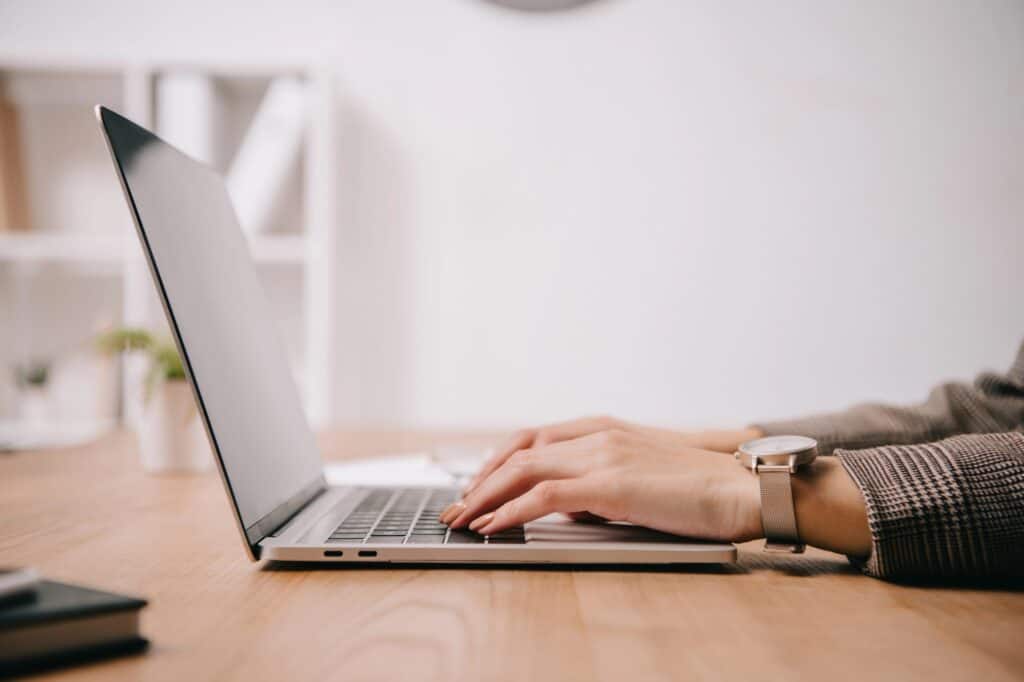 A woman in front of her laptop is searching for house removals company.