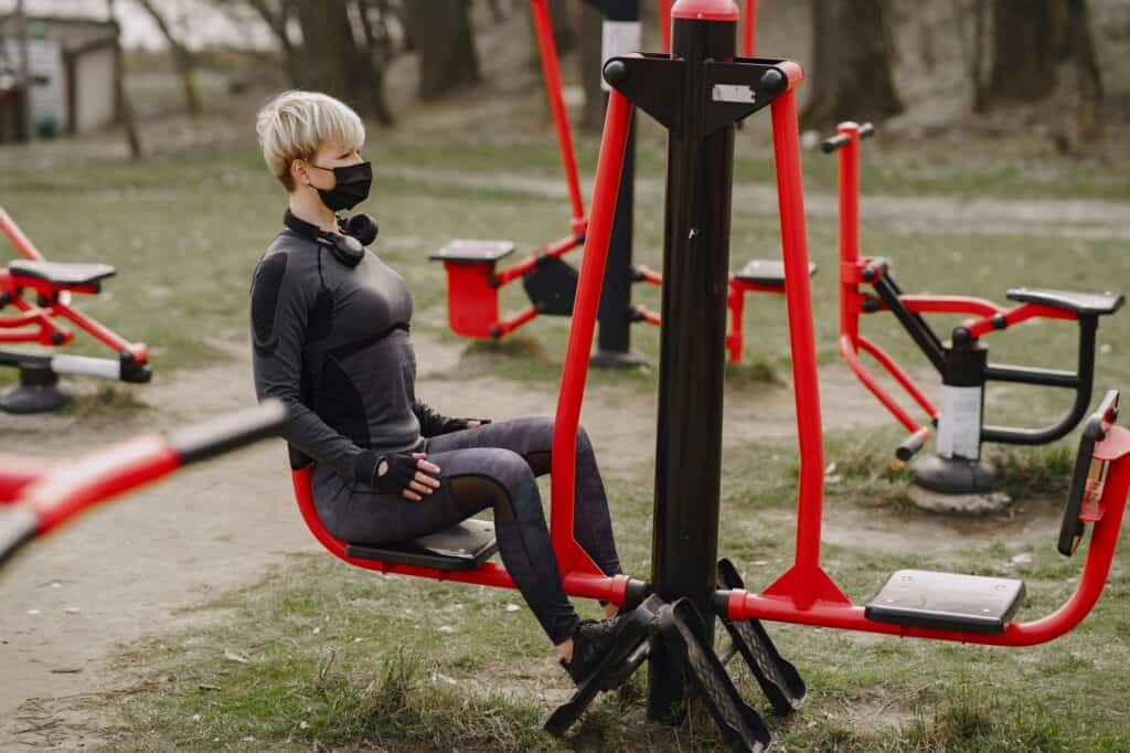 A woman is working out in an outdoor gym