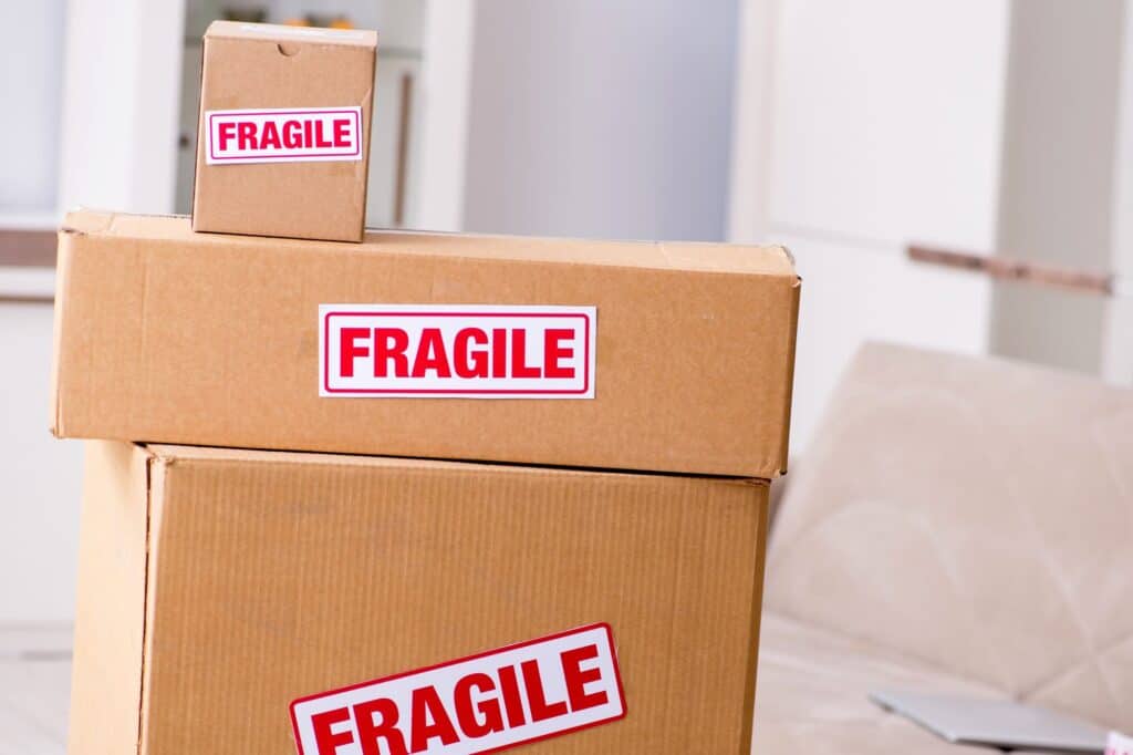 Moving boxes with 'Fragile' stickers in the concept of home removal services cost.