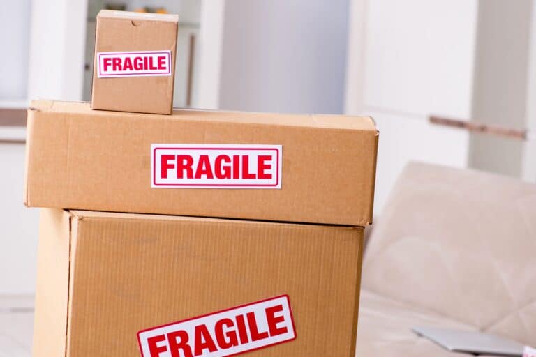 Moving boxes with 'Fragile' stickers in the concept of home removal services cost.