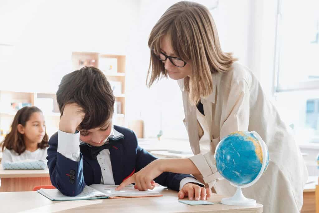 The teacher helping her student with classwork