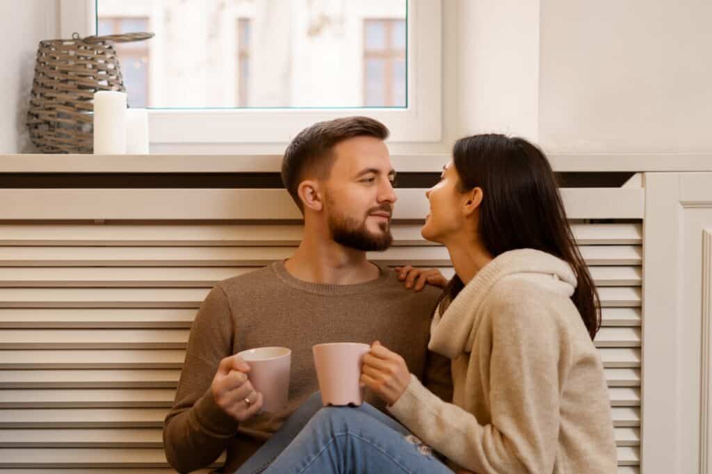 A loving couple enjoying their drinks after the house move in the concept of 'how to settle into a new home after moving to Wood Green'.