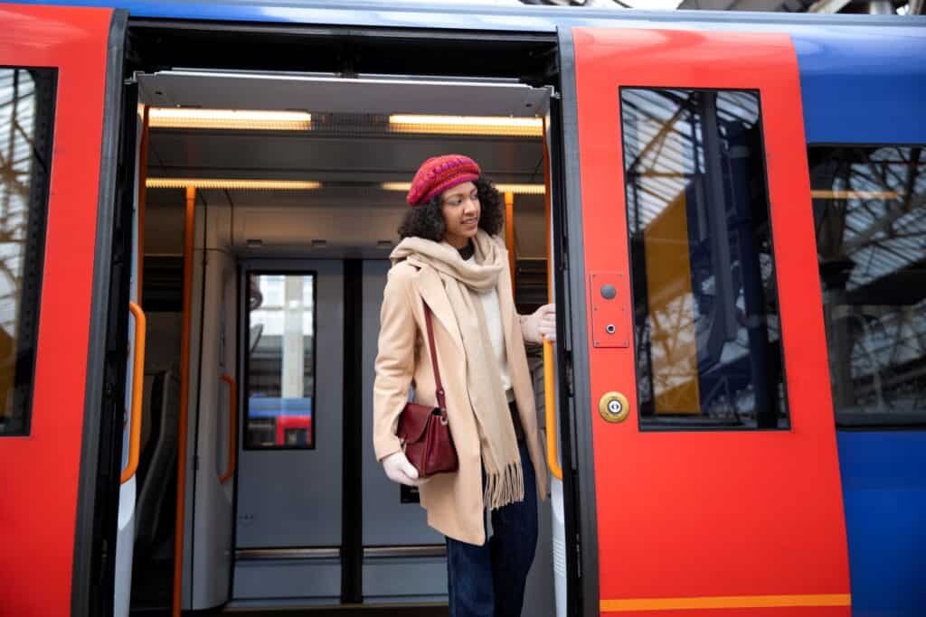 A young woman disembarking the train in the concept of 'how to use Wood Green's public transport'.