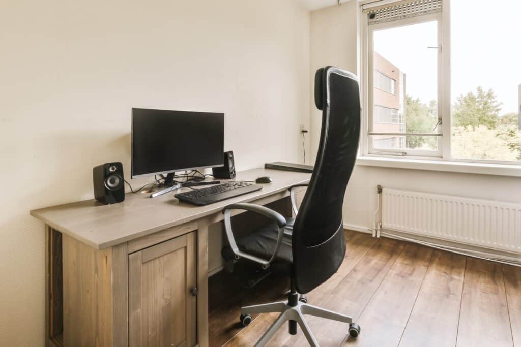 A wooden desk at huge chair in a home office in the concept of 'How to Move Large Furniture When Moving House to Wood Green'.